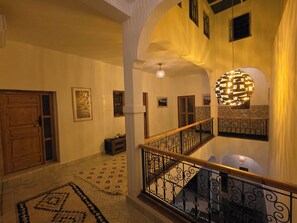A multi-level interior with a staircase, wooden doors, patterned rugs, and decorative lighting. - Riad Patio Des Amis Marrakech (Marrakech)