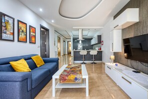 A modern living room with a sofa, coffee table, and artwork on the wall. - Modern and cosy 2 bedroom apartment PSCI1-1 (Mellieha)