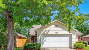 A single-story house with a white garage, a mailbox, and a well-maintained lawn. - Renovated 3BR Retreat With Game Room (Montgomery)