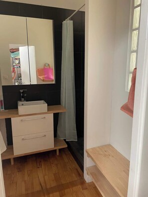 A bathroom with a mirror, a sink, a shower curtain, and a wooden floor. - La Famille Maison Piscine Toulouse Centre (Toulouse)