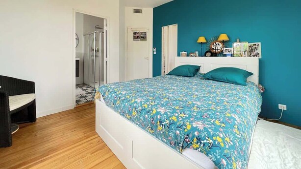 A bedroom with a bed, a chair, a wardrobe, and a door leading to a bathroom. - La Conviviale - Maison Familiale Avec Piscine (Toulouse)