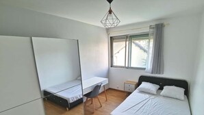A bedroom with a bed, a desk, a chair, a wardrobe, and a window. - Colocation Meubl e Ar nes Bail Individuel (Toulouse)
