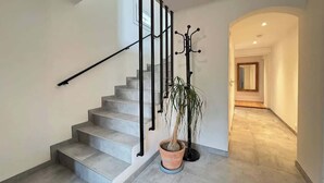 A staircase with a handrail, a potted plant, and a light fixture. - L Escapade 6p Maison Familiale Jardin Piscine (Boussens)