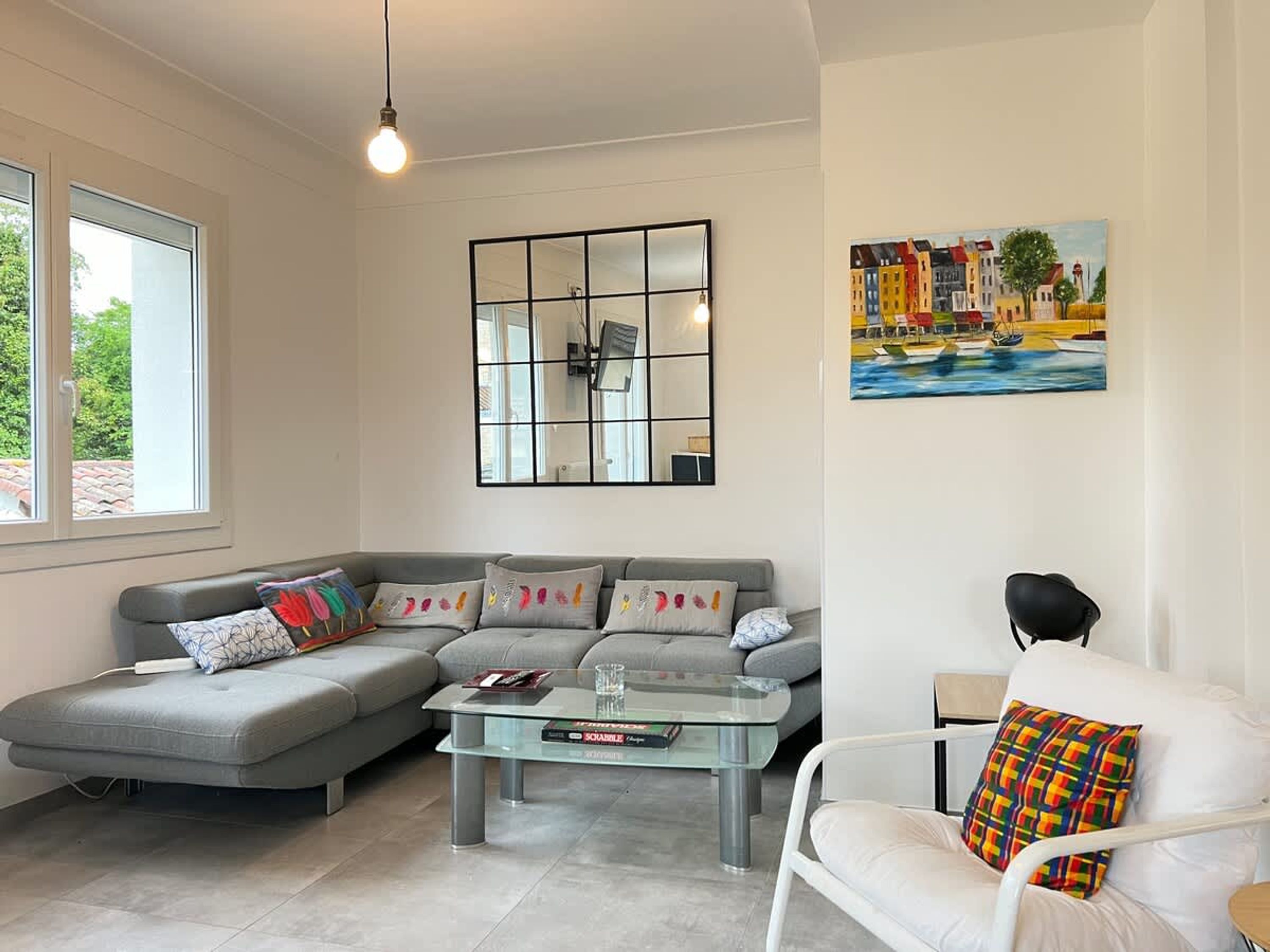 Una sala de estar moderna con un sofá, una mesita de centro de vidrio y una silla.