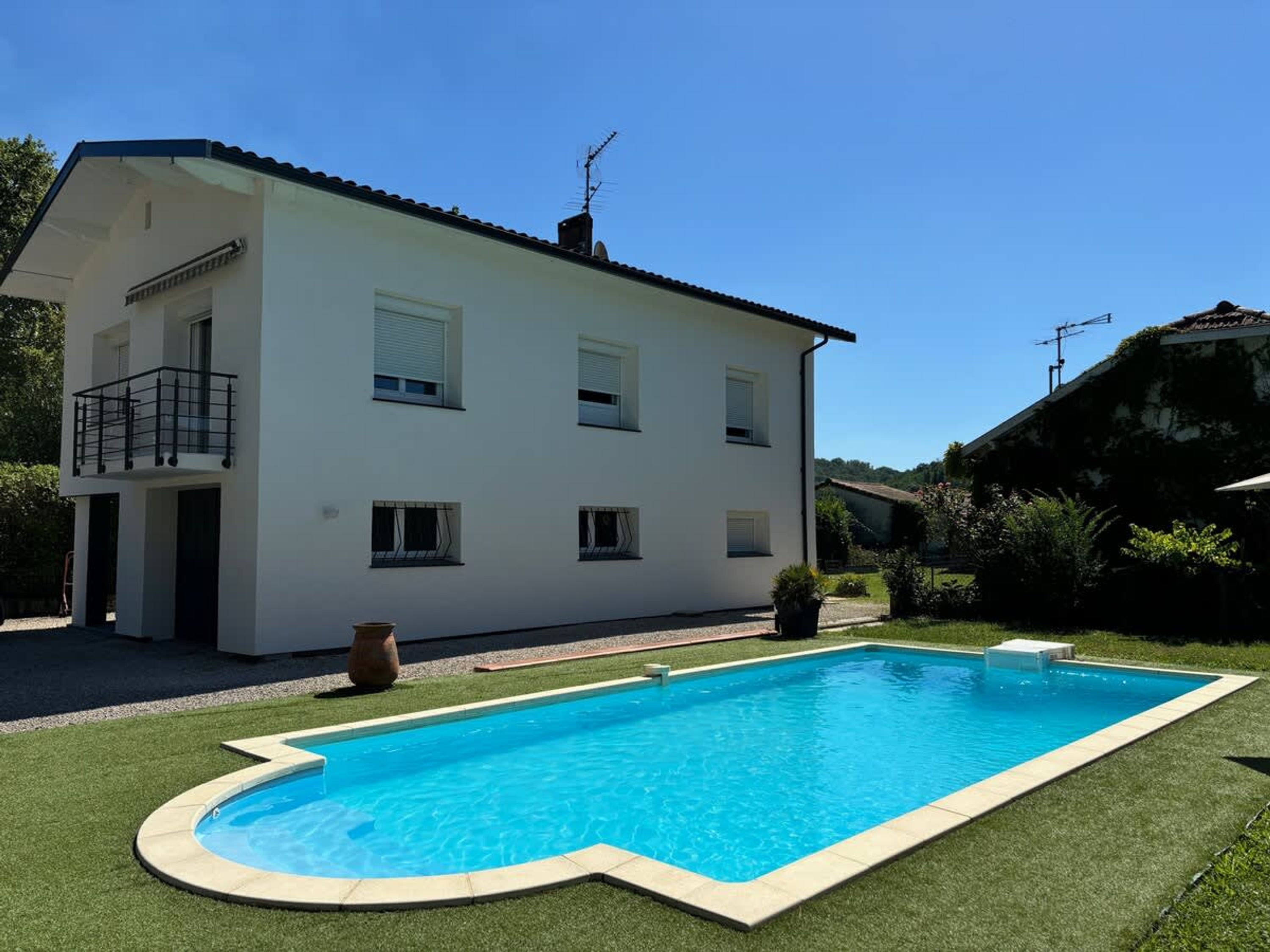 Ein zweigeschossiges Haus mit Swimmingpool.