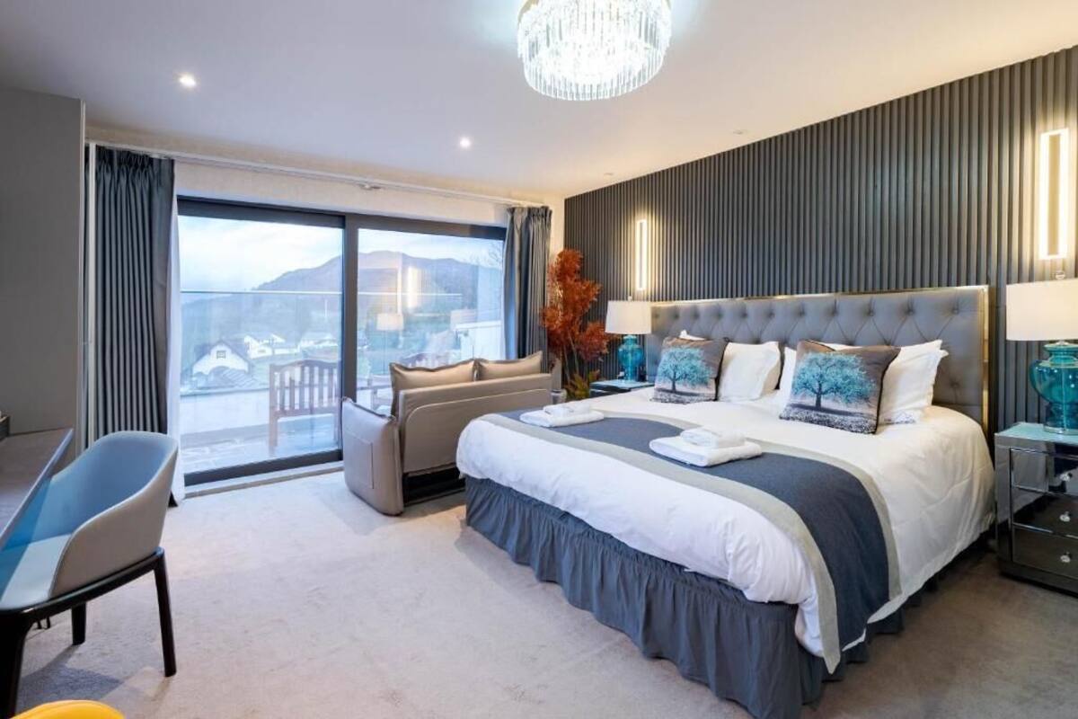 Ett modernt hotellrum med en stor säng, en sittgrupp och utsikt över omgivningarna.