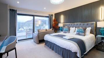 A modern hotel room with a large bed, a seating area, and a view of the outdoors.