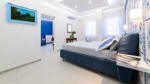 Un dormitorio moderno con cama, escritorio y televisor montado en la pared.