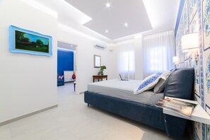 Ein modernes Schlafzimmer mit einem Bett, einem Schreibtisch und einem an der Wand befestigten Fernseher.