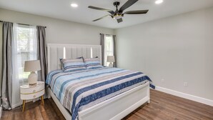 A bedroom with a bed, a nightstand, a ceiling fan, and a window with curtains. - Family Getaway w/ Fenced Yard in Orange Park! (Orange Park)