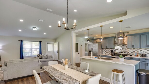 A modern kitchen with a central island, built-in appliances, and pendant lighting. - Family Getaway w/ Fenced Yard in Orange Park! (Orange Park)