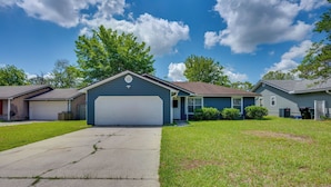A residential house with a garage, a driveway, and a lawn. - Family Getaway w/ Fenced Yard in Orange Park! (Orange Park)