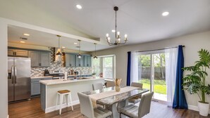 A modern kitchen with a central island, stainless steel appliances, and pendant lighting. - Family Getaway w/ Fenced Yard in Orange Park! (Orange Park)