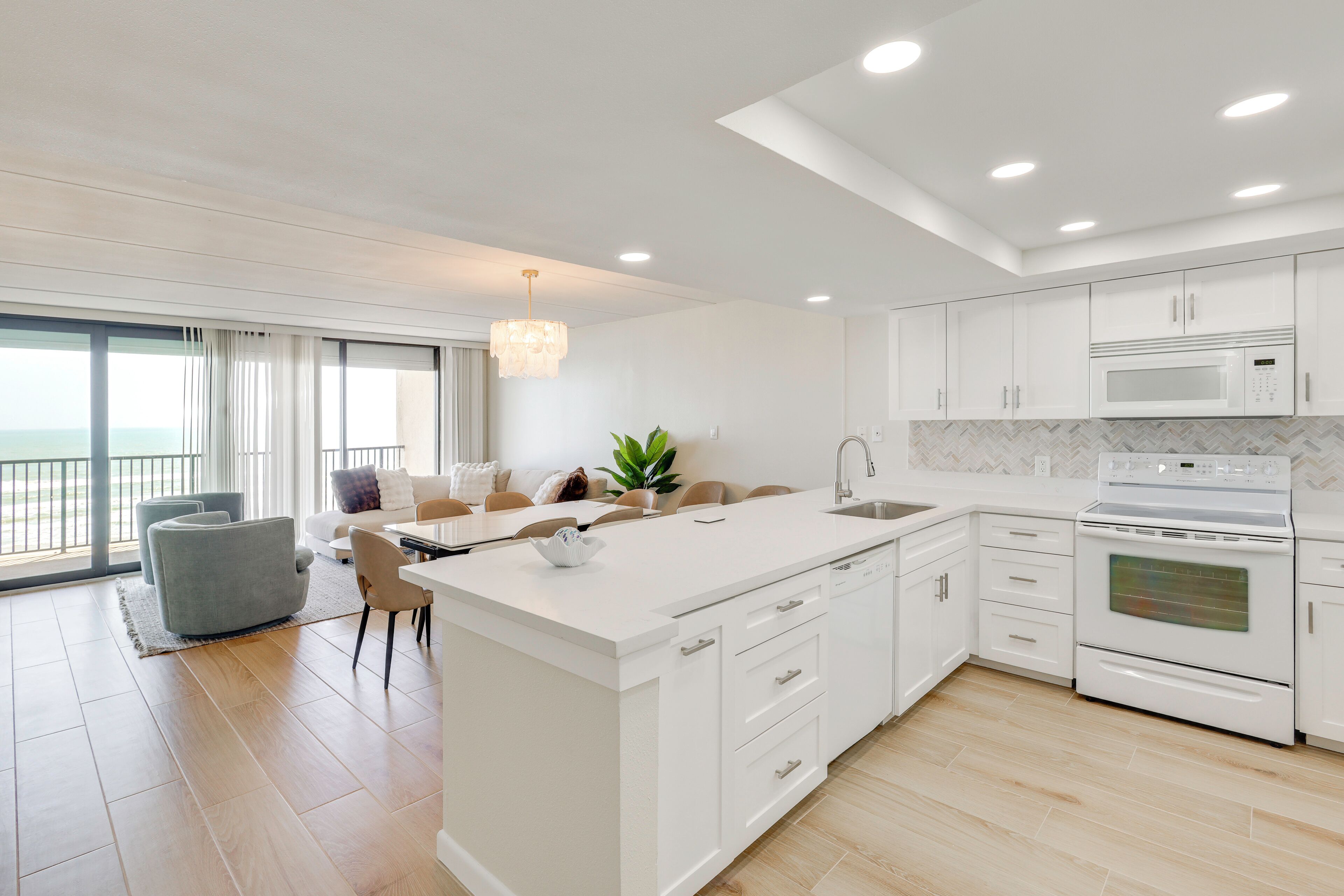 A modern kitchen with white cabinetry, a built-in microwave, and an oven.