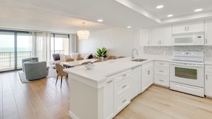 A modern kitchen with white cabinetry, a built-in microwave, and an oven. - Stunning Views, Luxe Decor: Suntide III - Unit 805 (South Padre Island)