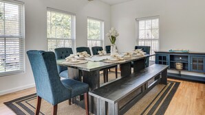 A dining area with a long table, blue upholstered chairs, a bench, and a blue cabinet with a pot on top. - 4 Mi to Beach & Dtwn! Charming Fairfield Home (Fairfield)