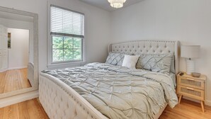 A bedroom with a bed, a nightstand, a lamp, a window with blinds, and a door. - 4 Mi to Beach & Dtwn! Charming Fairfield Home (Fairfield)