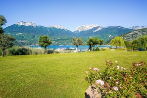 A grassy field with a lake and mountains in the background. - Lake view & terrace - Private parking for 4 people (Duingt)