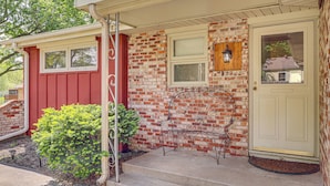 A house with a red exterior, a white door, and a small porch with a bench. - Fenced Yard & Patio! Shawnee Getaway 2 Mi to Dtwn (Shawnee)