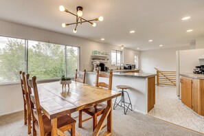 A spacious kitchen with a wooden table and chairs, a built-in island, and large windows. - Walk to Palmer Park! Mtn-view Haven w/ Deck & Yard (Colorado Springs)