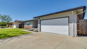 A residential house with a garage, a lawn, and a driveway. - Near Fresno State & Malls! Family-friendly Home (Fresno)