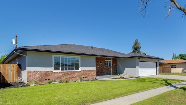 A single-story house with a garage, a front lawn, and a clear sky. - Near Fresno State & Malls! Family-friendly Home (Fresno)