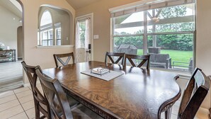 A dining area with a wooden table, chairs, and a view of the outdoors. - Feel at Home: Quiet Neighborhood, Emtek Smart Lock (Spring)