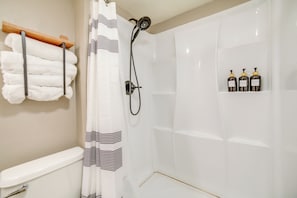 A bathroom with a shower, toilet, towel rack, and toiletries shelf. - Walkable Home in Dtwn Caldwell! 1 Mi to Campus (Caldwell)