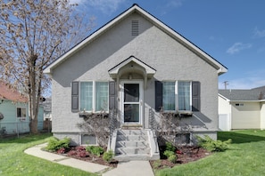 A two-story house with a front porch, a small front yard, and a clear blue sky. - Walkable Home in Dtwn Caldwell! 1 Mi to Campus (Caldwell)