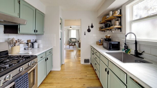 A kitchen with a stove, microwave, sink, and green cabinets. - Walkable Home in Dtwn Caldwell! 1 Mi to Campus (Caldwell)