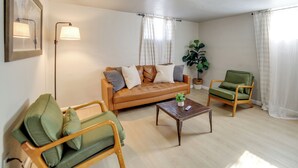 A living room with a sofa, armchair, coffee table, and a floor lamp. - Walkable Home in Dtwn Caldwell! 1 Mi to Campus (Caldwell)