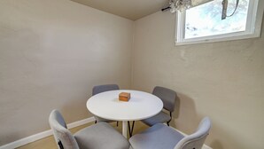 A corner room with a round white table, four grey chairs, a window with a curtain, and a small wooden box on the table. - Walkable Home in Dtwn Caldwell! 1 Mi to Campus (Caldwell)
