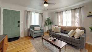 A living room with a sofa, armchair, coffee table, and a door. - Walkable Home in Dtwn Caldwell! 1 Mi to Campus (Caldwell)