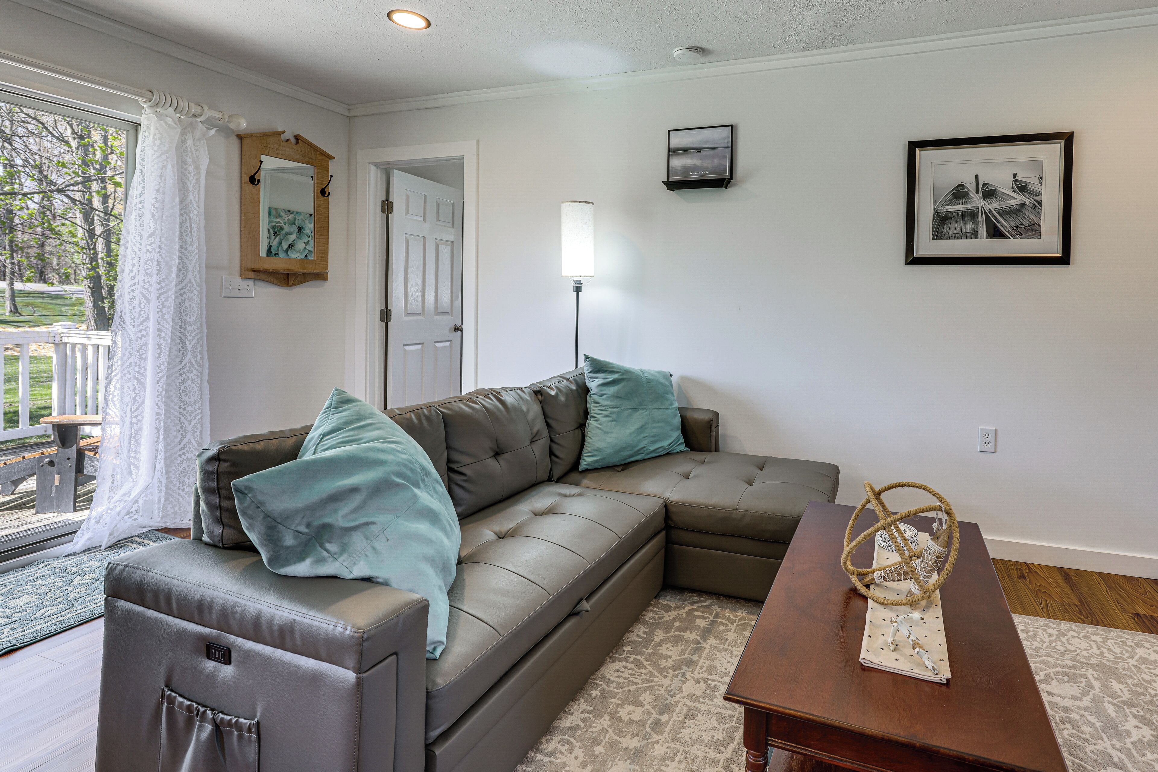A living room with a sectional sofa, a coffee table, a lamp, and a framed picture on the wall.