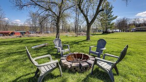 A grassy outdoor area with a fire pit and Adirondack chairs. - Dog-friendly Waneta Lake Home w/ Lake Access! (Hammondsport)