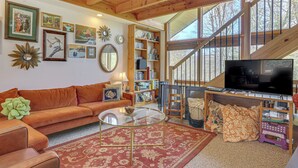 A cozy living room with a sofa, coffee table, and bookshelves. - Catskills Serenity! Cozy Vintage Cabin on 10 Acres (Grahamsville)