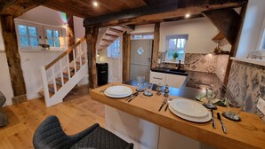 Una cocina rústica con una isla de madera, una escalera y vistas al exterior.