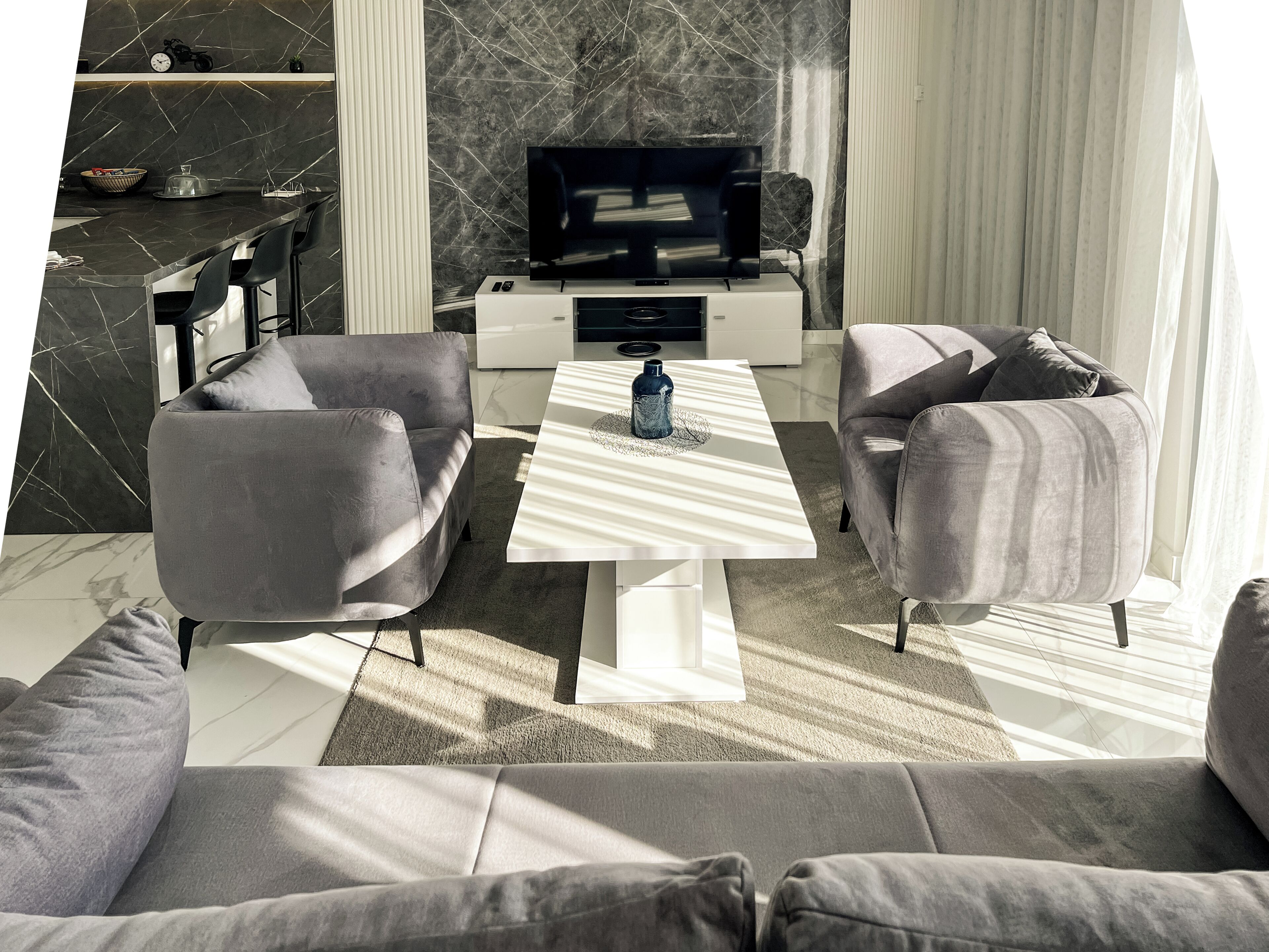 A modern living room with a sofa set, a coffee table, and a TV.