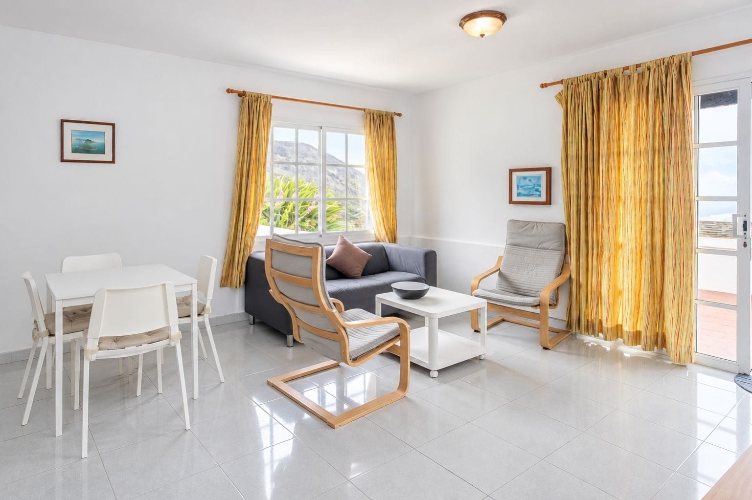 Una sala moderna con sofá, sillas, una mesa de comedor y cortinas.