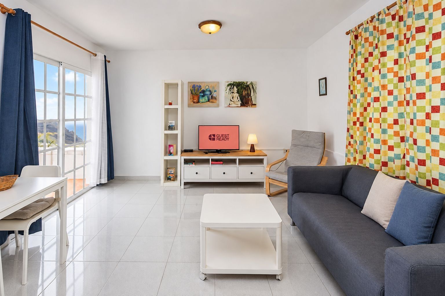 Una sala de estar moderna con un sofá, una mesa de centro, un televisor y una estantería.