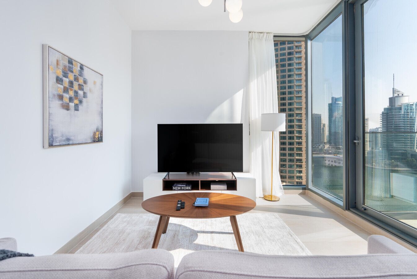 Una sala de estar moderna con una televisión de pantalla plana, una mesa de centro y un sofá.