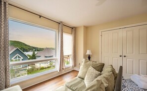 A room with a large window, a sofa, a lamp, and a wardrobe. - Gray Fox Lakeview near wisp and attractions (McHenry)