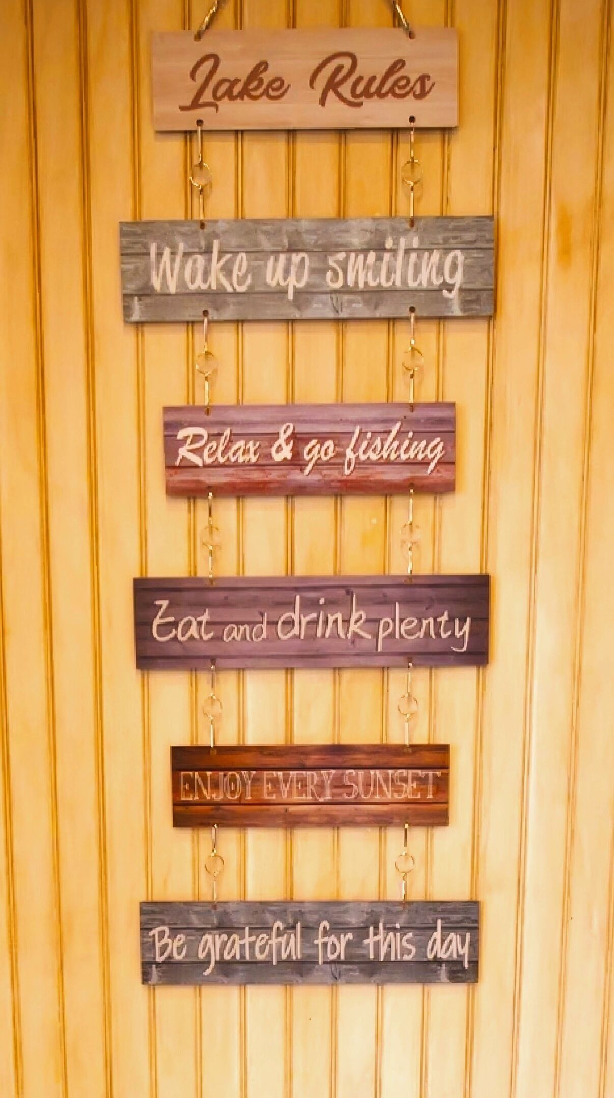 A wall with wooden signs displaying motivational phrases.