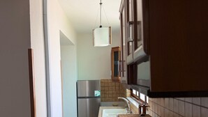 A kitchen with a stainless steel refrigerator, a sink, and a wooden countertop.