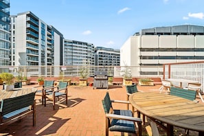 A rooftop patio with outdoor seating, a grill, and potted plants. - Spacious 3-Bed Apartment in Canberra CBD (Canberra)