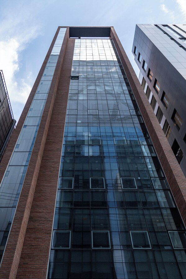 Un immeuble de grande hauteur doté d’une façade moderne en verre et de détails en brique.