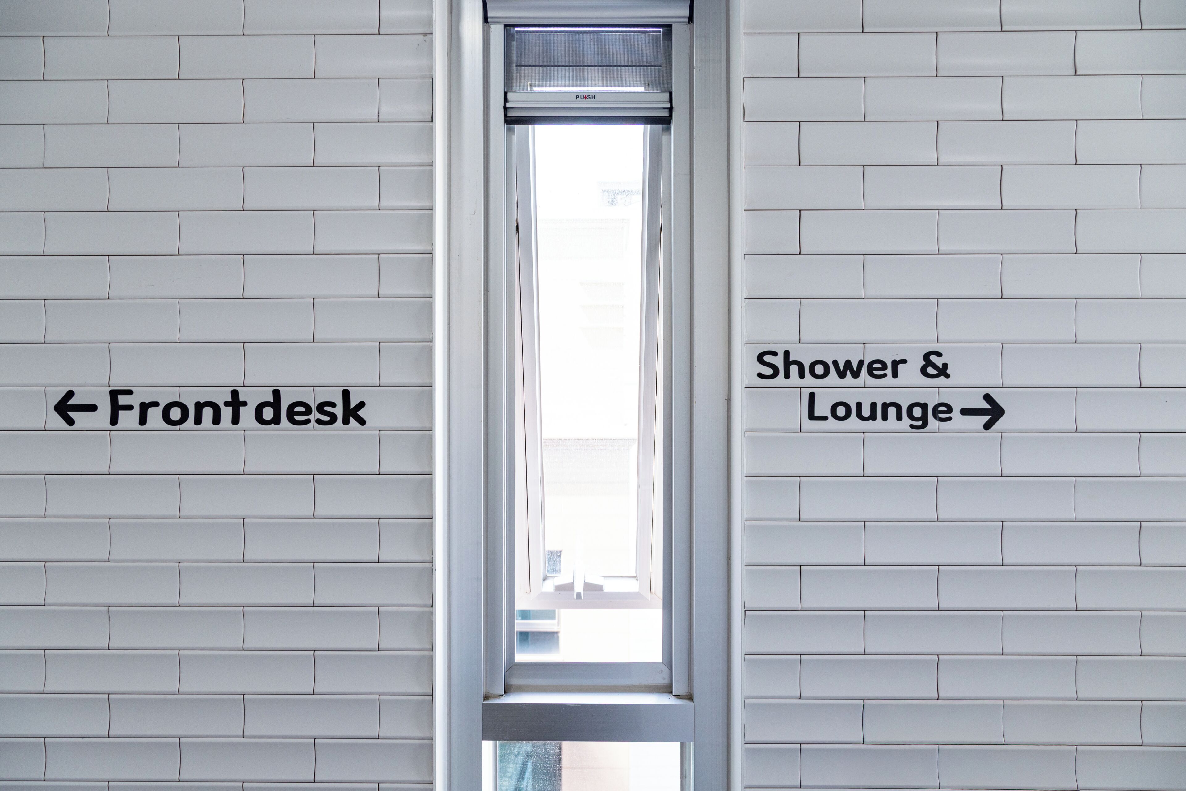A bathroom with a window, labeled 'Front desk' on the left and 'Shower & Lounge' on the right.