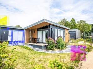 A modern house with a patio, a small garden, and a clear sky. - Stunning private villa for 2 people with pool, A/C, WIFI, TV and terrace (Tholen)
