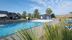 A swimming pool with lounge chairs and a small building, surrounded by greenery and a clear sky. - Wonderful private villa for 2 guests with pool, WIFI, A/C, TV and terrace (Tholen)