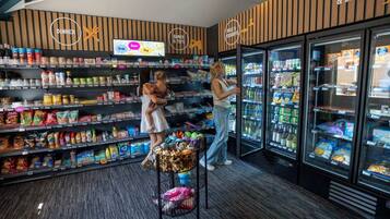 Een automaatruimte met snacks, dranken en verschillende merken, inclusief een snelheidsbetaalsysteem.